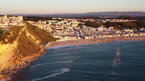 Stadt-Nazare-Portugal-Während-Der-Goldenen-Stunde-Des-Sonnenuntergangs,-Luftschwenk-Rechts-Sichtbar