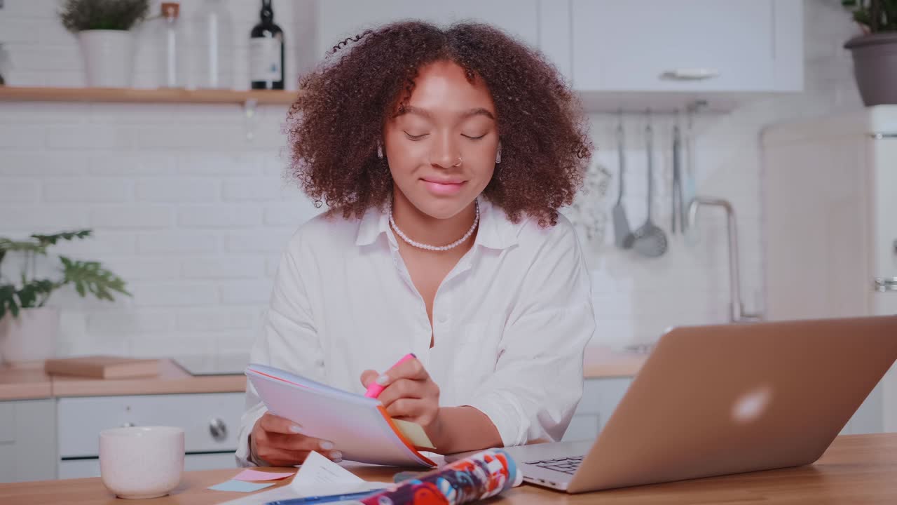Giovane studentessa afroamericana segue lezioni a distanza al laptop.
