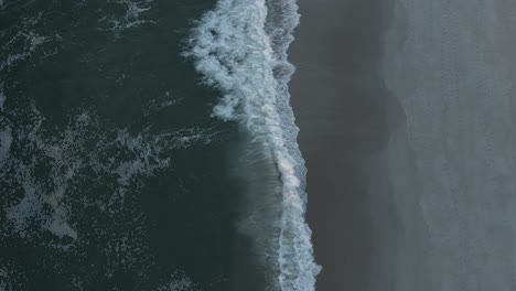 Vertical-Shot-Of-Ocean-Waves-With-White-Foam-Roll-On-Empty-Sandy-Shoreline-At-Long-Beach-Island-In-New-Jersey,-USA