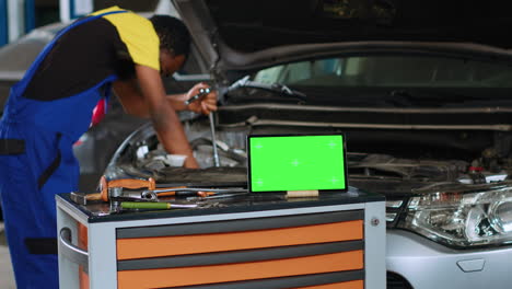 ingeniero de automóviles al lado de la tableta de llave de croma