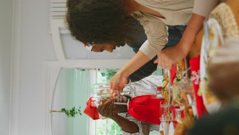 Vertikales-Video-Einer-Familie-Aus-Mehreren-Generationen-Mit-Weihnachtsmützen,-Die-Beim-Weihnachtsessen-Zu-Hause-Anstößt