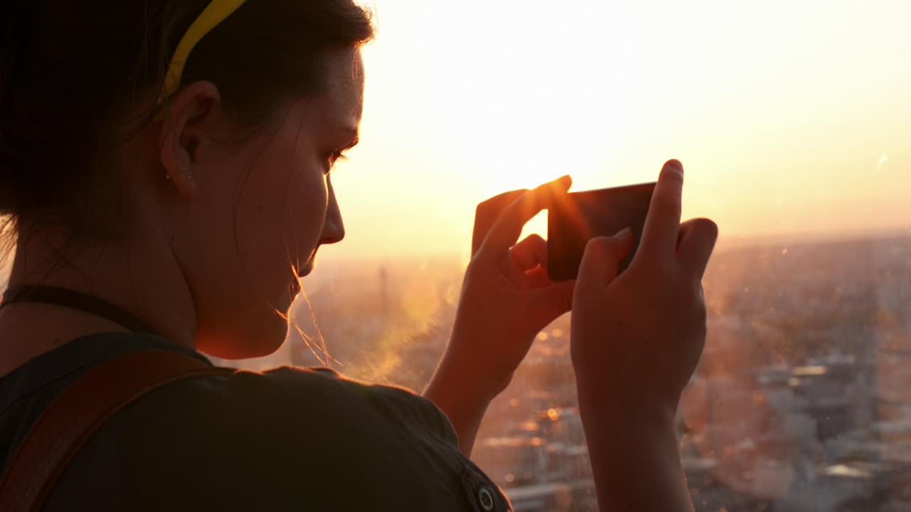 Turista fotografiando el atardecer en el skyline de Londres desde The Shard.