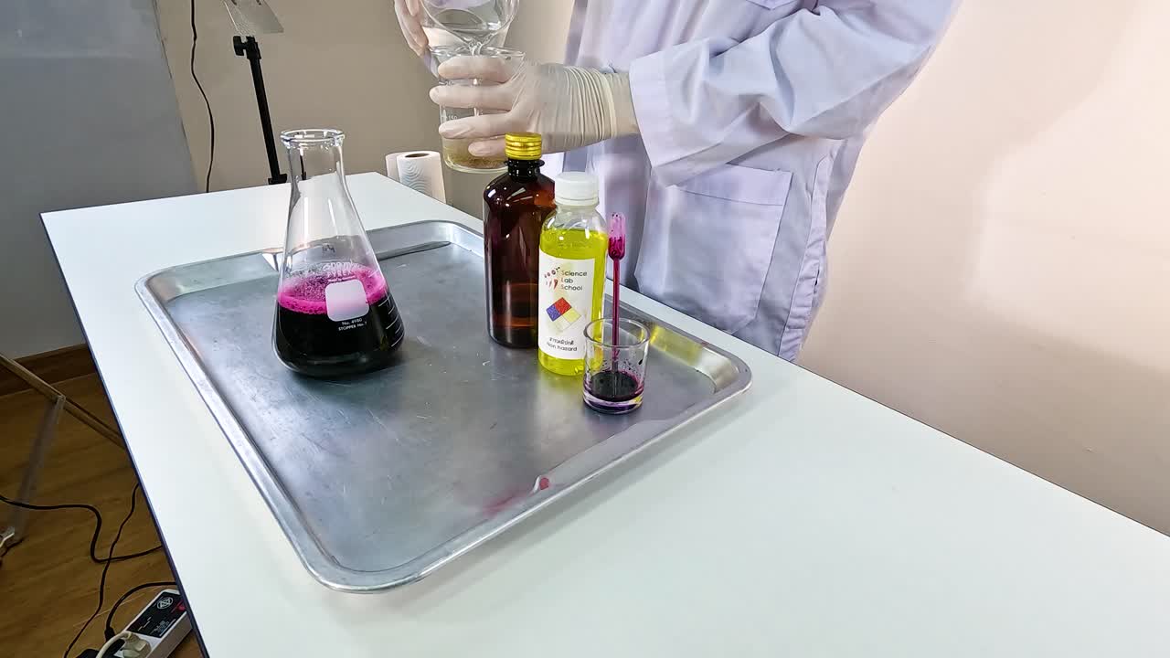 Scientist conducts a vibrant chemical experiment using beakers and colored liquids on a lab table