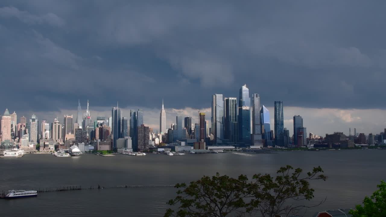 광각 맨해튼 스카이라인은 구름이 가득한 폭풍우 날씨에 구름을 통해 빛을 비추고 있습니다.