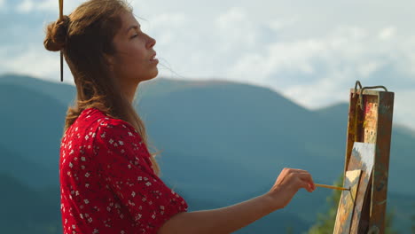 meditative painter drawing picture in summer mountains. closeup artist painting