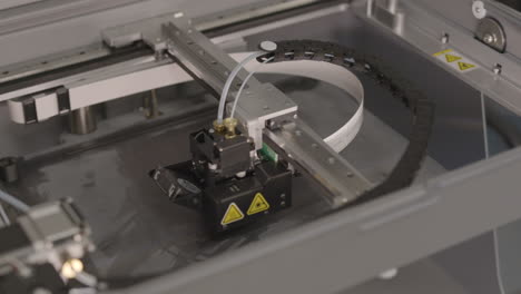 overhead view of 3d printer working as print head creates a plastic component slow motion