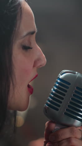 cantante femenina apasionada cantando con profunda emoción, sosteniendo un micrófono antiguo, en un fondo borroso, destacando su intensa y sincera actuación