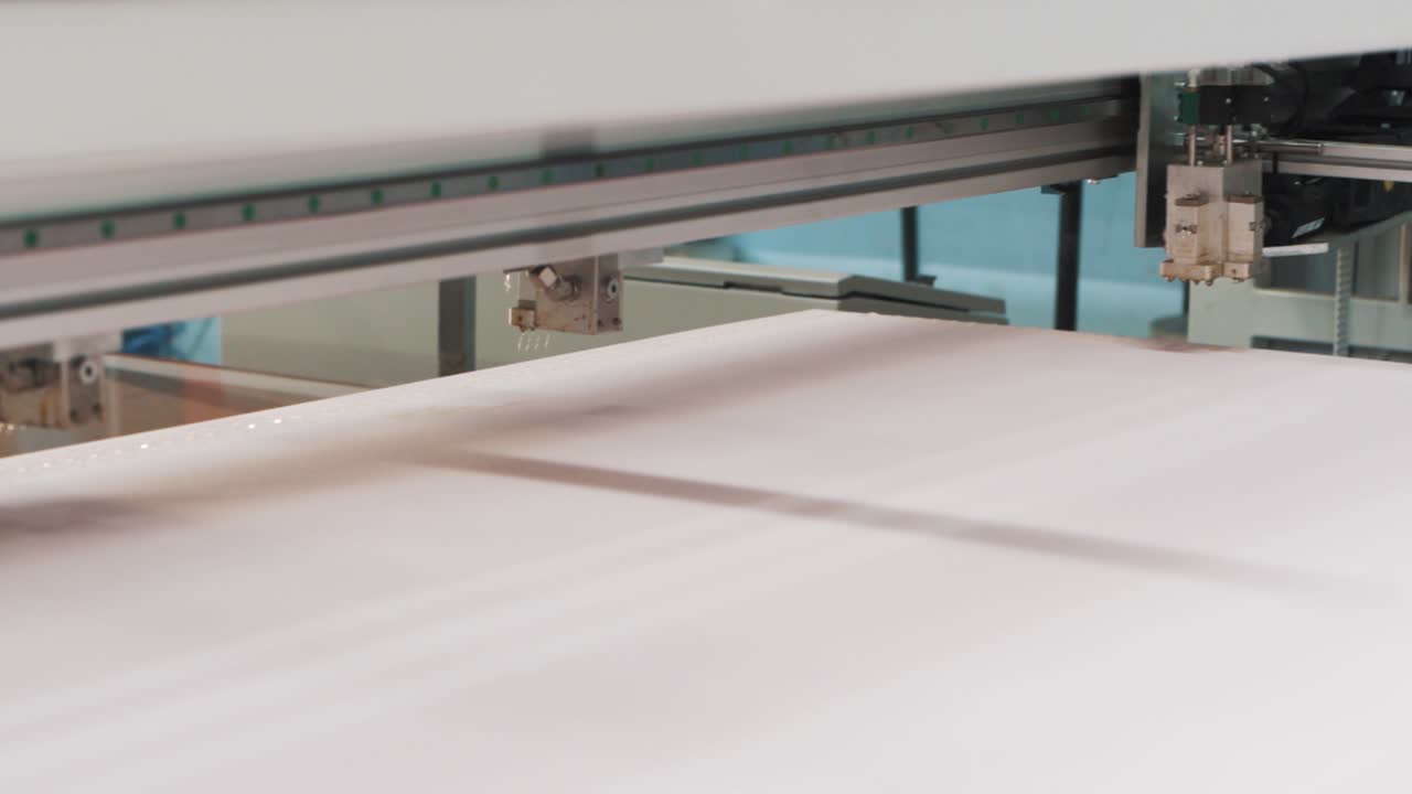 직물 공장에서 매트리스 제조를 위해 발포체에 자동 접착제를 바르는 컴퓨터 지원 기계의 클로즈업