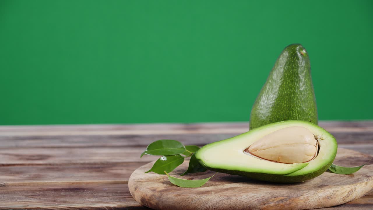 나무 테이블 위에 신선한 아보카도를 회전시니다.