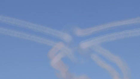 planes execute complex maneuvers with smoke trails