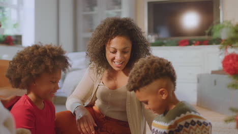 Familia-Intercambiando-Y-Abriendo-Regalos-Alrededor-Del-árbol-De-Navidad-En-Casa.