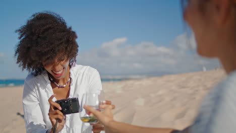 happy photographer taking photo on sandy beach. carefree friends enjoying summer