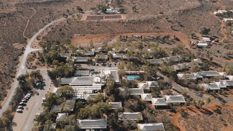 Umlaufende-Drohnenaufnahme-Der-Stadt-Yulara-Enthüllt-Uluru-Im-Nördlichen-Territorium-4k