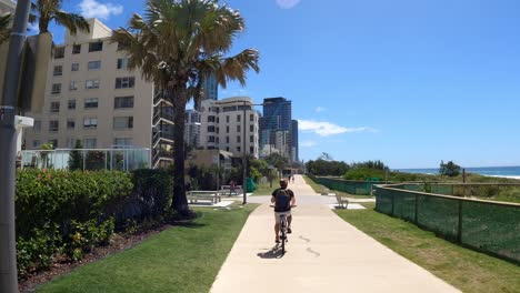 person cycling on a sunny urban path