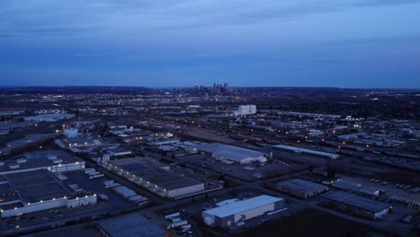 Nighttime-drone-flight-over-illuminated-warehouses