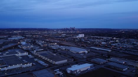 nighttime drone flight over illuminated warehouses