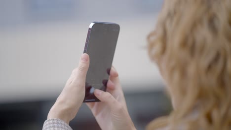 woman taking picture of a building with a smartphone