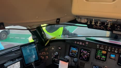 la tripulación de la rampa limpiando las ventanas de la cabina vista desde adentro antes del primer vuelo del día