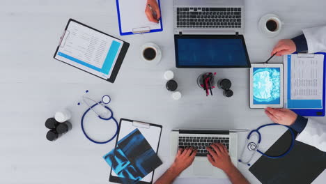 Specialist-doctor-analysing-human-brain-using-tablet-on-flatlay