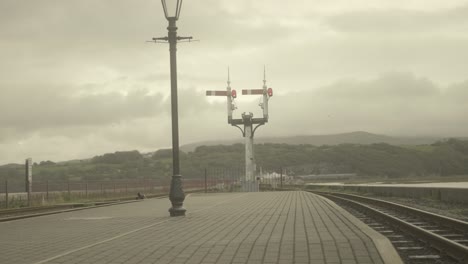 pov railroad signals ahead as a train rolls down the track, snowdonia, wales, uk