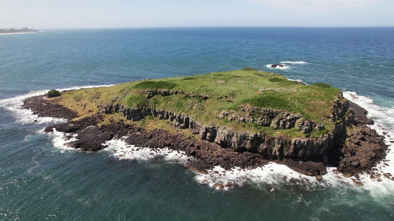 Lush Green Rocky Cook Island With Sea Waves Crashing In New South Wales, Australia. aerial orbiting shot