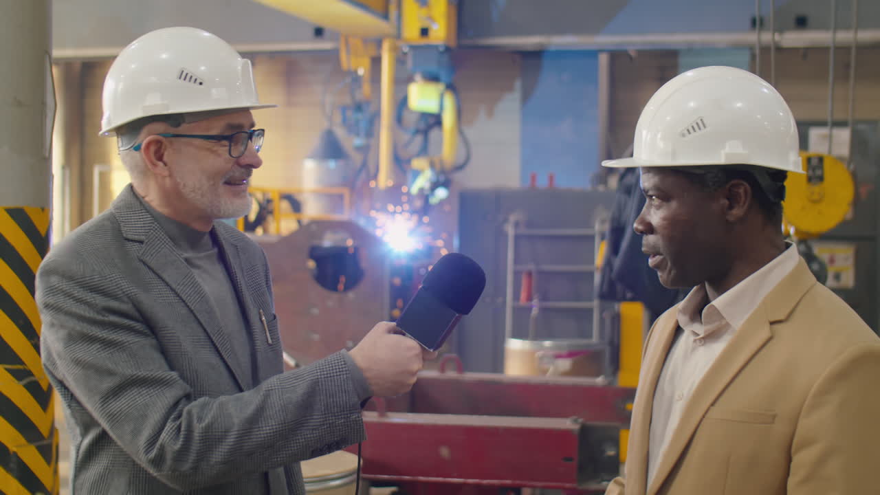 Reporter televisivo che intervista un ingegnere di fabbrica afroamericano