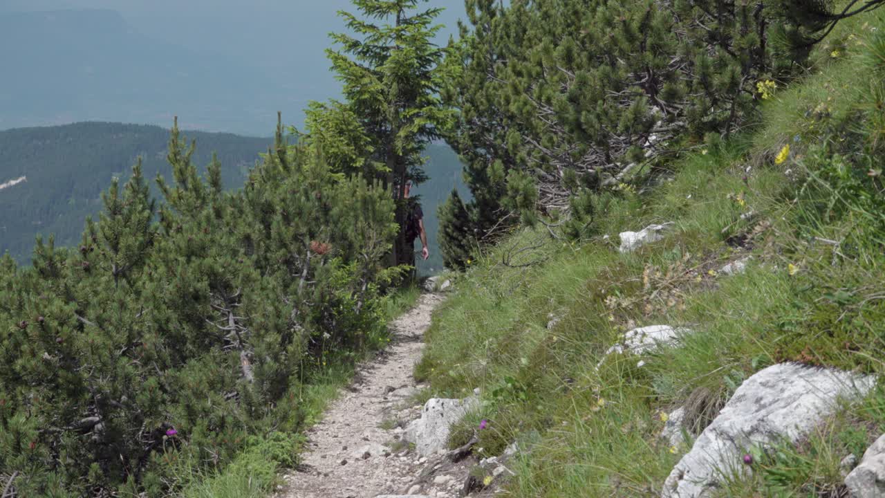 A hiker enjoying his day in nature walking along a trail leading down from Mount Weisshorn - Corno Bianco, South Tyrol, Italy