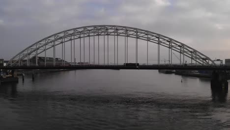 vehicles crossing the arch bridge over noord river in alblasserdam, netherlands