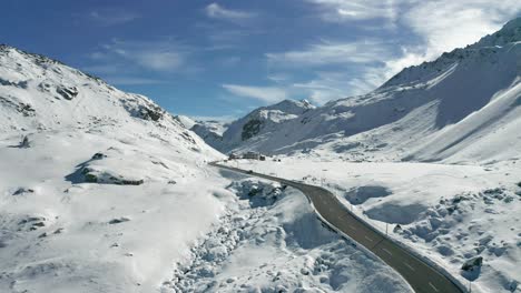 froward drone flight following a car on a snowy mountain road
