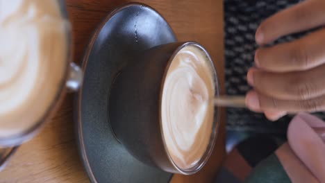 person stirring a latte