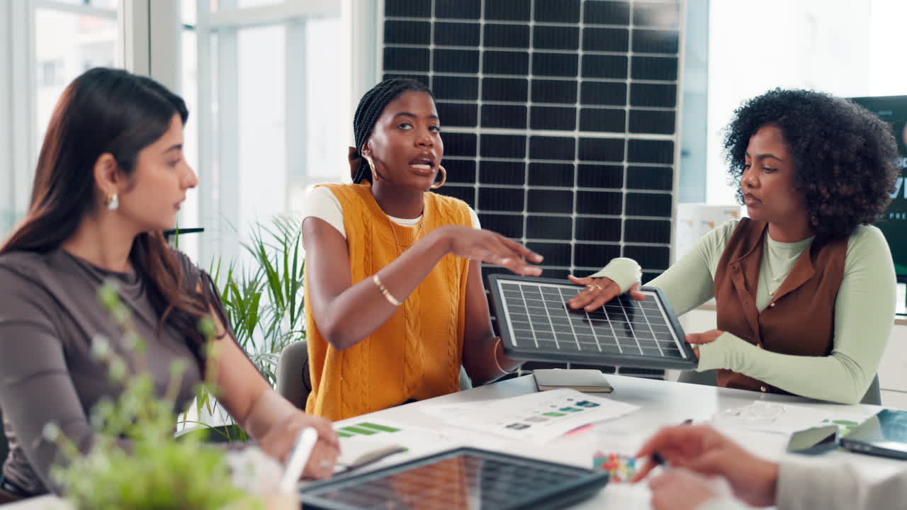 Diverse Women Discussing Solar Panel Technology in a Business Meeting
