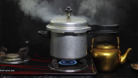 a cooker is whistling with smoke in an indian kitchen