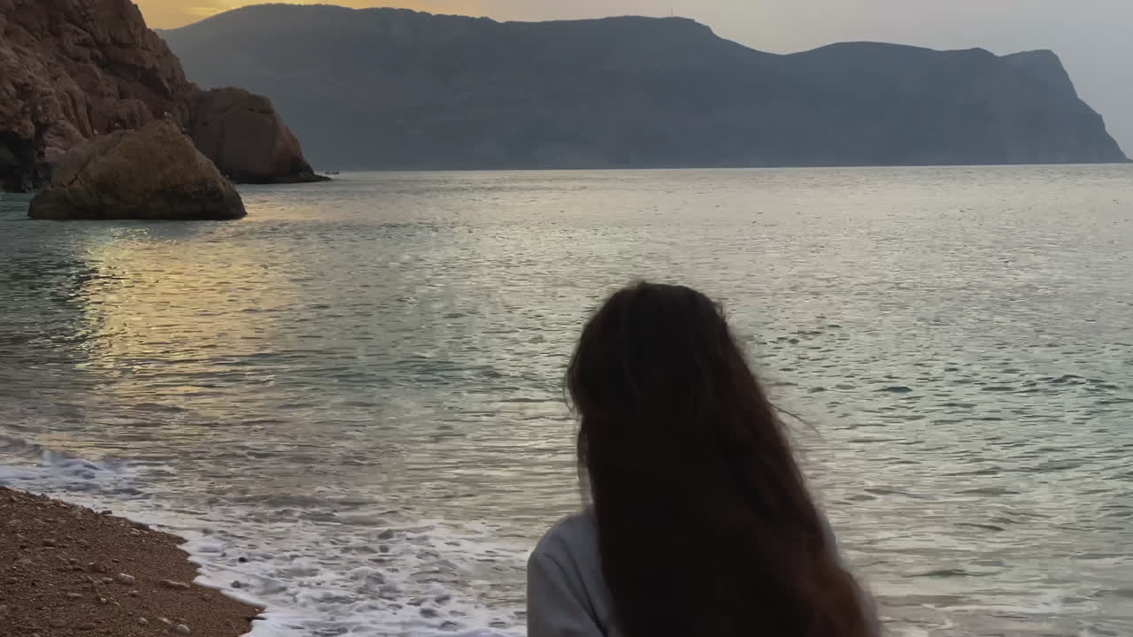 해가 지는 해변에 있는 여자