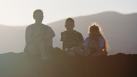 family silhouetted against a hazy mountain sunset