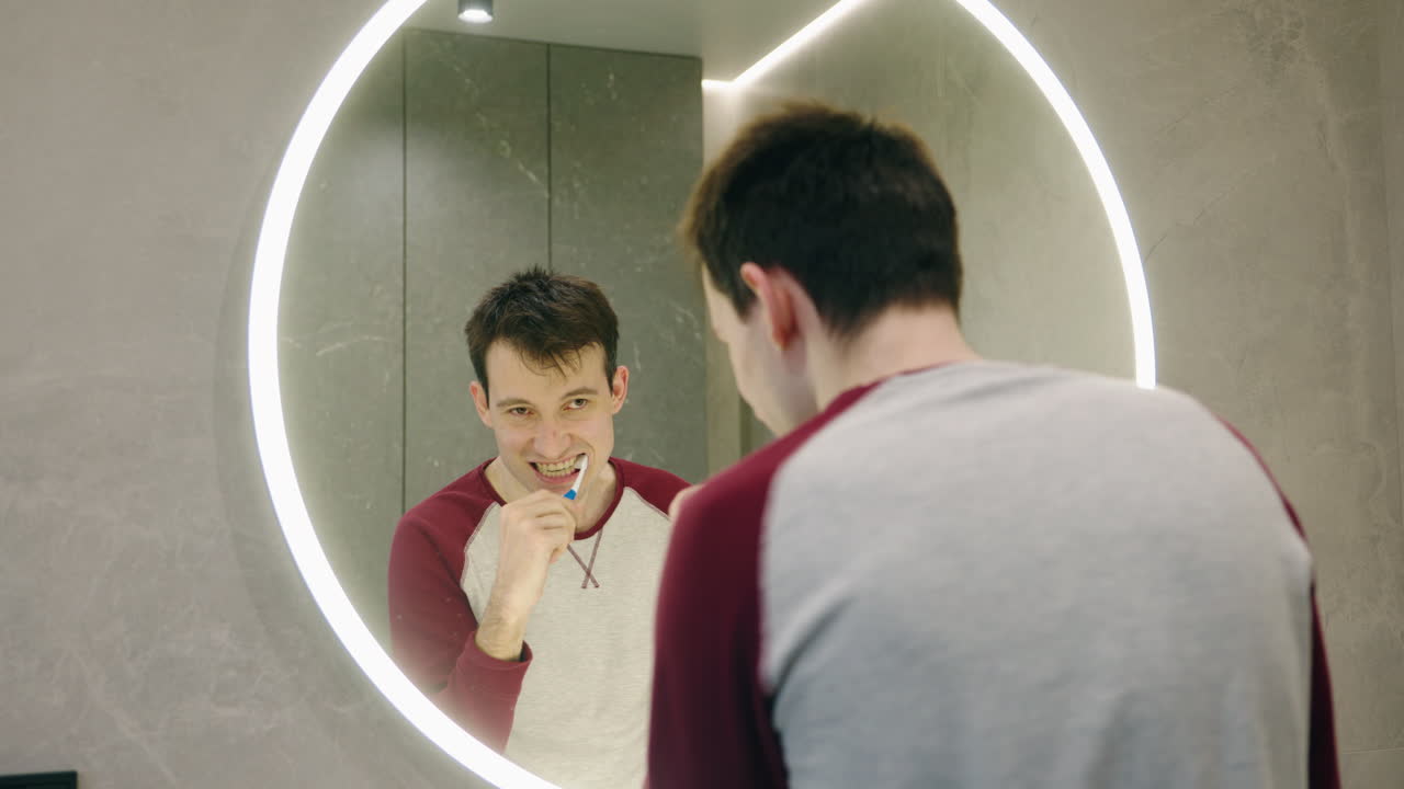 Uomo che si lava i denti in bagno