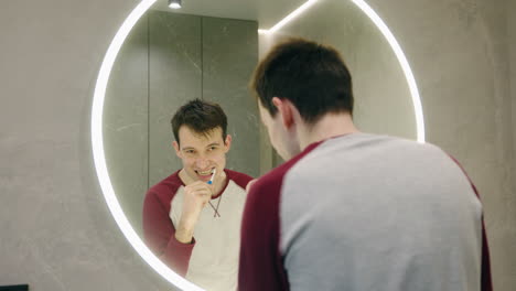 hombre cepillándose los dientes en el baño