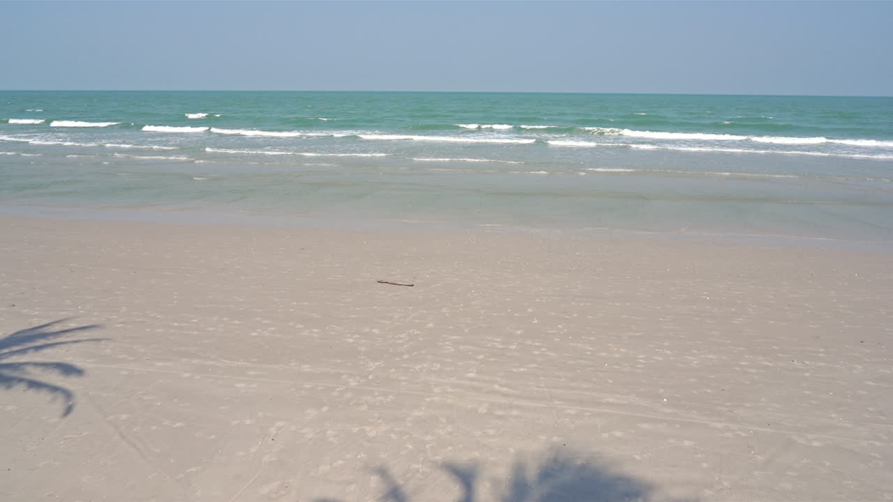 목가적인 열대 해변, 하얀 모래, 가벼운 파도와 푸른 수평선, 정적 슬로모