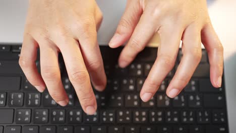 close up hand of a business woman typing keyboard laptop computer on desk office