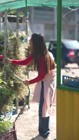 woman watering plants at a garden center