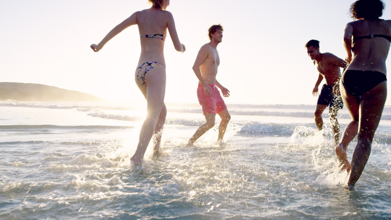 해가 지면 바다 에서 수영 하는 다양한 친구 들 의 그룹