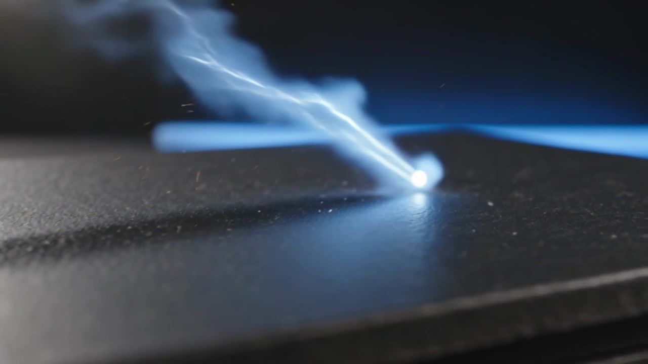 Punto di plasma blu-bianco pulsante di energia che si muove su piastre nere in studio, con un filamento che si trascina