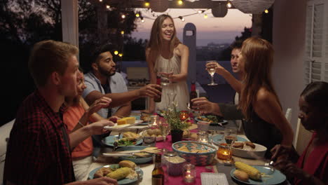 Amigos-Hacen-Un-Brindis-Durante-Una-Cena-En-Una-Terraza-En-La-Azotea,-Ibiza,-Filmada-En-R3d