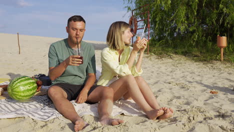 un couple fait un pique-nique sur la plage.