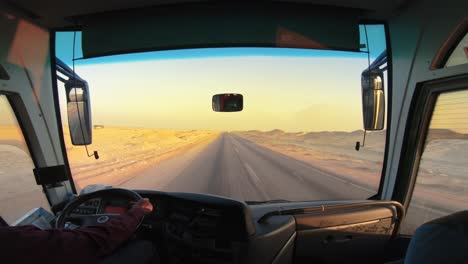 inside of a bus with tourists driving on the empty desert road in sahara, egypt