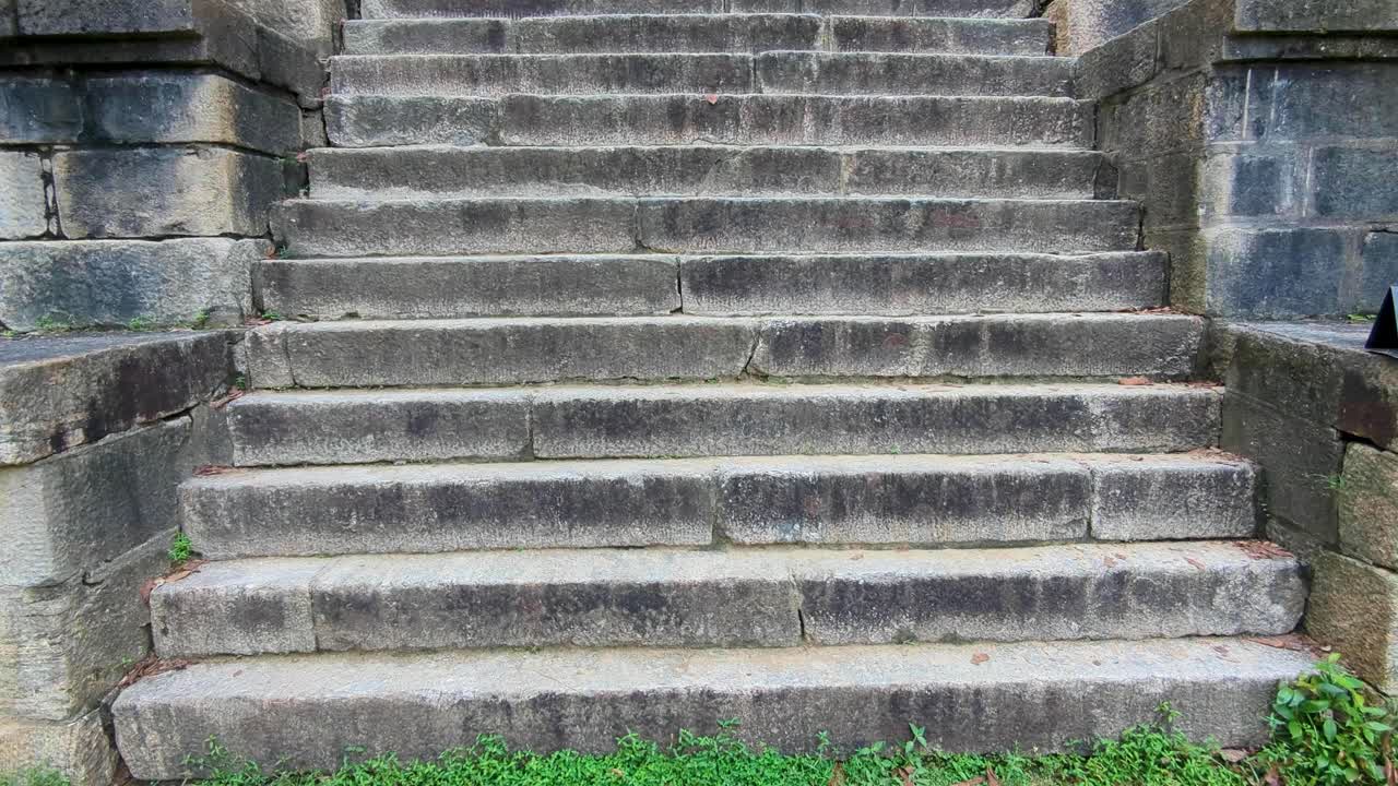 Pan up of steep ancient stone stairway steps of ancient Yapahuwa Rock Fortress in Sri Lanka