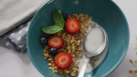 Video-Mit-Müsli-Und-Obst-In-Einer-Keramikschüssel-Auf-Einer-Weißen-Küchenarbeitsplatte