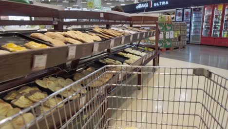 walking through a supermarket with the shot from the shopping cart. bakery products