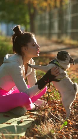 woman and her pug in the autumn park