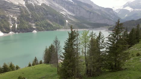 circling through the abundant forest of fir trees with the oeschinen valley and lake in the background