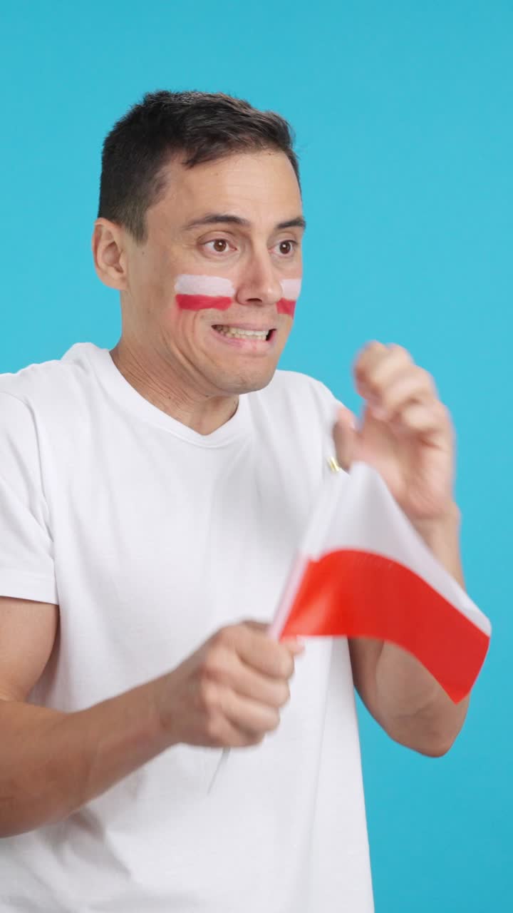 Nervous man cheering for Poland during a match looking away
